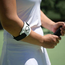 Load image into Gallery viewer, Tennis player wearing a Bandit Elbow Brace while gripping a tennis racquet.