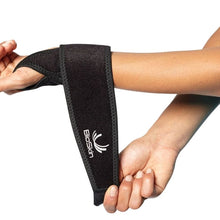 Load image into Gallery viewer, Person is strapping the compression wrist wrap around the left wrist.