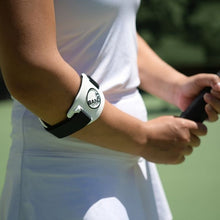 Load image into Gallery viewer, Tennis player wearing a Bandit Elbow Brace while gripping a tennis racquet.
